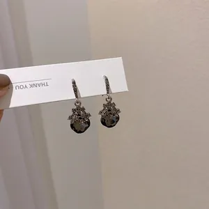Detail of silver drop earrings featuring smoke gray geometric crystals and zircon inlay