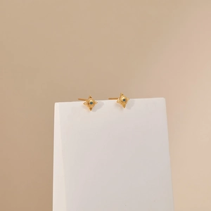 Detail of 18K gold plated star earrings with blue enamel center on a white stand