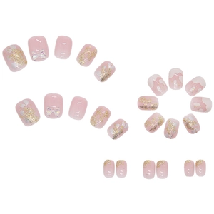 Pink French press-on nails with 3D bows, gold glitter, and white cloud patterns