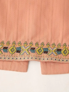 Detailed close-up of ethnic geometric embroidery and side slit on light orange vest