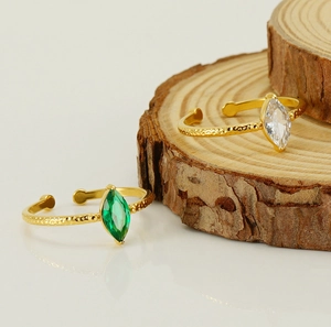 Dettaglio di anelli d'oro regolabili con pietre a taglio marquise verdi e trasparenti