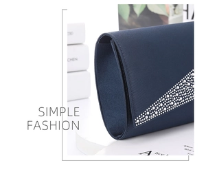 Detail of dark blue satin evening clutch with elegant rhinestone embellishment