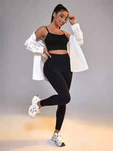 Conjunto de yoga con sujetador deportivo, leggings negros y camisa blanca