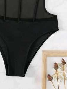 Detail of mesh paneling and ribbed texture on a black high-cut sexy one-piece swimsuit