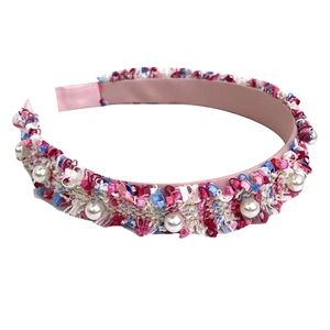 Pink woven headband with multicolored tweed fabric and white pearl embellishments