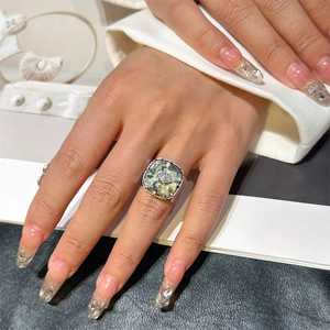 Vintage stainless steel open ring with square green stone and diamond accent on model hand