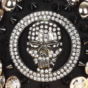 Punk style baseball cap featuring crystal skull motif and black cone studs on fabric