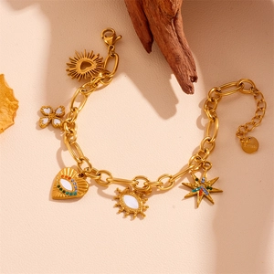 Detailed view of gold stainless steel necklace with evil eye and heart charms on wood