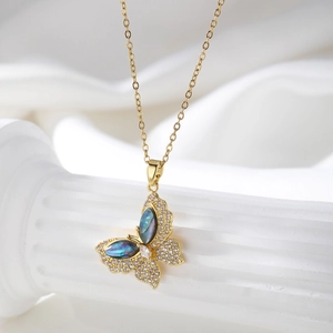 Detail of gold butterfly necklace with blue shell inlay and shimmering zircons