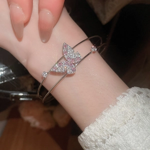Close-up of silver double-layer bracelet with pink zircon butterfly on wrist