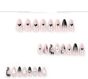 Detail of gothic pink and black gradient press-on nails with silver heart and cross charms