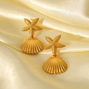 Golden starfish and seashell drop earrings on luxury silk background with elegant shine