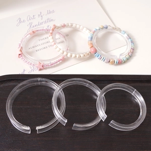 Macro shot of transparent acrylic C-ring bracelet displays with clear jewelry stand details