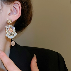 Detail of vintage gold butterfly earrings with champagne crystal drops and beaded tassels