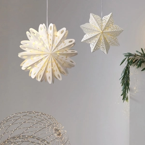 White paper snowflake lanterns with hollow design and warm glowing LED lights