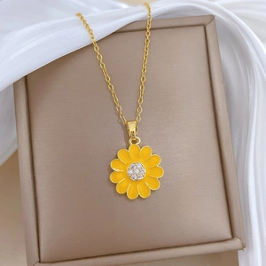 Elegant gold titanium sunflower necklace with yellow petals and diamond accents on silk