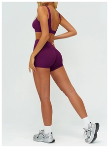 Dettaglio degli shorts da yoga a vita alta con design push-up e tessuto sportivo viola