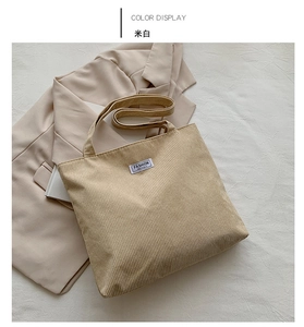 Close-up of creamy white corduroy tote bag featuring a Fashion Instinct label