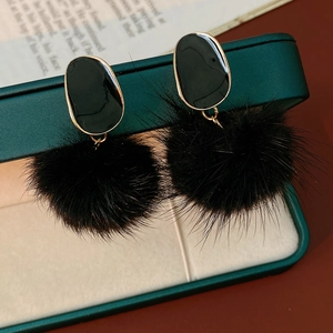 Detail of twisted oval fuzzy earrings with black enamel finish on a vintage display box