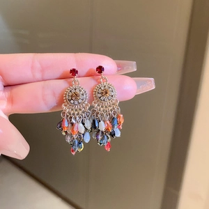 Gros plan de boucles d'oreilles vintage à pompons avec perles en cristal coloré