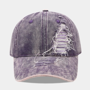 Detailed macro view of distressed purple washed denim baseball cap with vintage frayed holes