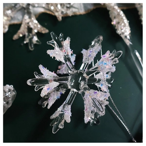 Macro view of transparent snowflake ornament with holographic sequins on green background