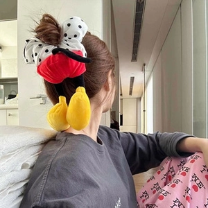 Close-up of plush cartoon mouse ear headband styled on a braided bun hairstyle