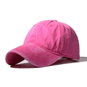 Detailed macro view of the distressed washed cotton texture on a pink baseball cap