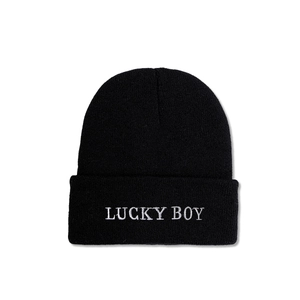 Detailed close-up of Lucky Boy white embroidery on a black knitted beanie hat