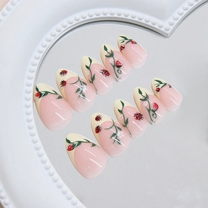 Press on nails with ladybug and floral art on almond shaped french tips in soft pink