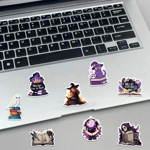 Gothic witch stickers with magic motifs displayed on a silver laptop surface