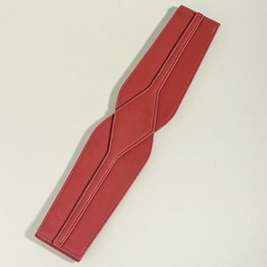 Detailed view of red leather wide waist belt with fine stitching and natural texture