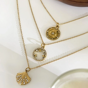 Three gold stainless steel necklaces with shell pendant, starry ring, and vintage coin