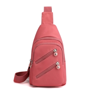 Pink nylon crossbody sling bag with multiple zipper pockets and adjustable strap