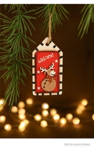 Détail d'une étiquette de Noël en bois avec renne 3D suspendue à une branche