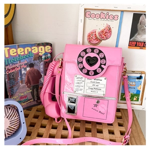 Pink retro telephone shaped crossbody bag with glossy finish and vintage rotary dial design