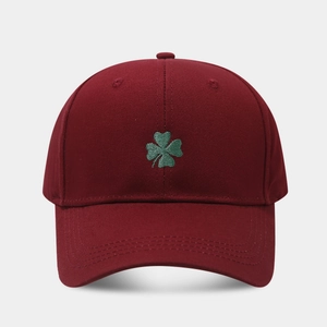 Close-up of green shamrock embroidery on a burgundy cotton twill baseball cap