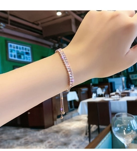 Close-up of rose gold adjustable bracelet with sparkling zircon stones on a female wrist