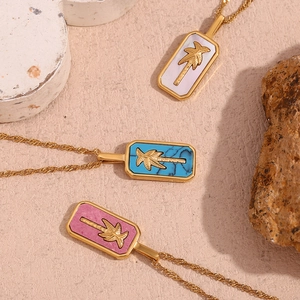 Detailed macro view of 18K gold plated necklaces featuring carved palm tree rectangle pendants