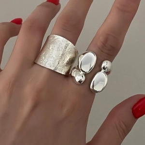Detail of silver dual-layer rings with textured wide band and irregular organic sphere design