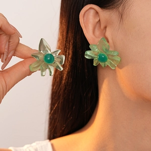 Minimalist green resin flower earrings for women worn on ear and held in hand