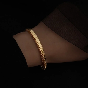 Macro di un bracciale a squame di serpente in oro 18 carati sul polso di una modella