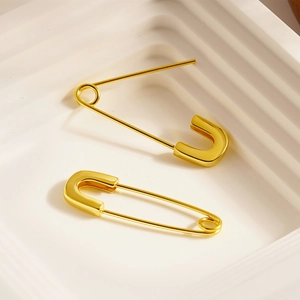 Polished gold paperclip earrings in high-shine stainless steel on a white platform