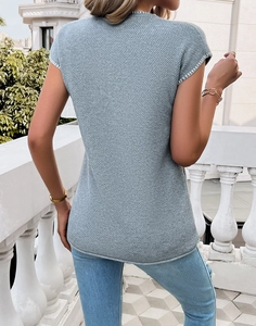 Rear view of women's blue textured knit short sleeve sweater with white piping details