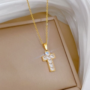 Macro detail of gold cross pendant necklace inlaid with sparkling cubic zirconia crystals