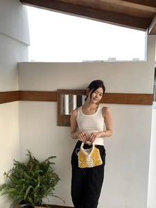 Detail of yellow and white hand-woven hollow bag with elegant cotton rope texture