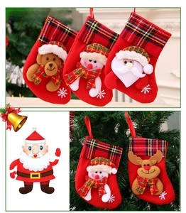 Close-up of red Christmas stockings featuring festive embroidery and plaid cuffs