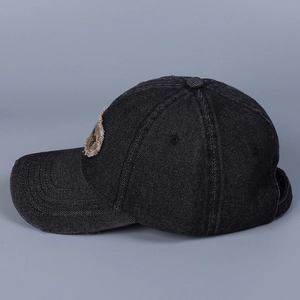 Vista laterale dettagliata del berretto da baseball in denim nero lavato con toppa ricamata
