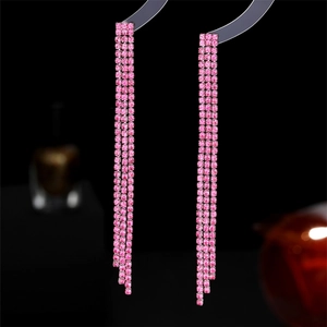 Makroansicht langer funkelnder rosa Strassohrringe mit mehrlagigen Quasten-Details