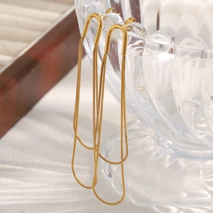 Close-up of minimalist long chain tassel earrings in 18K gold plated stainless steel